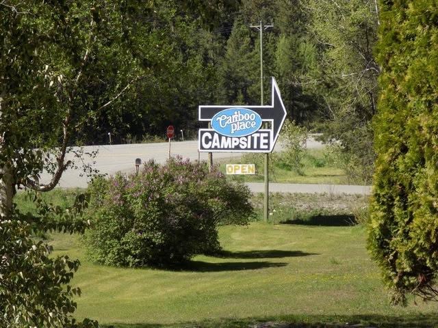 Entrance sign seen across the lawn at Cariboo Place Campsite